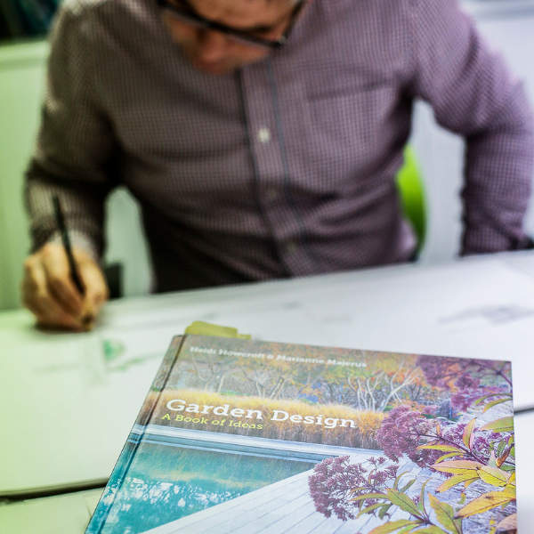 Image of Garden Designer at desk working, garden design text in the foreground.